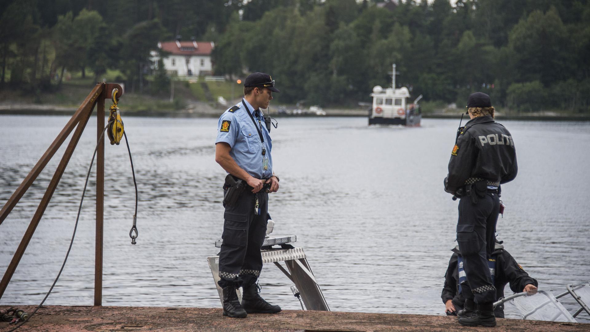 Polizisten stehen an der Schiff-Anlegestelle für die Überfahrt auf die Insel Utoya.