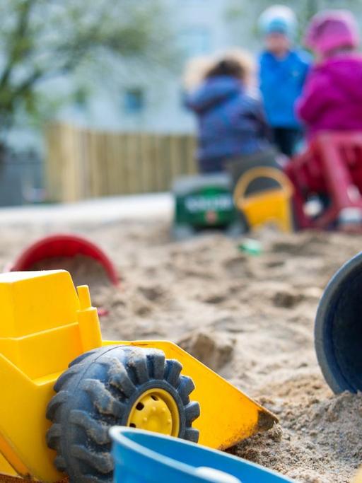 Spielzeug liegt am 18.04.2016 in einem Sandkasten in einer Kindertagesstätte
