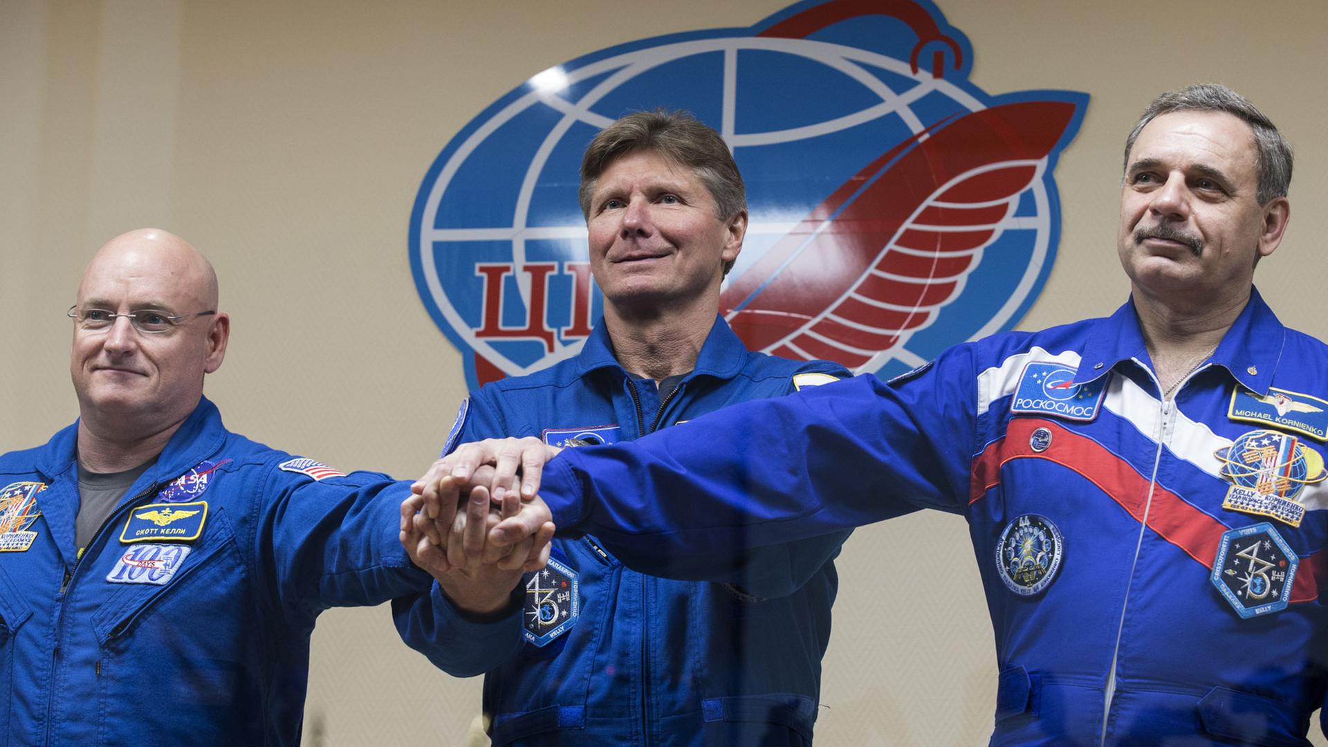US austronaut Scott Kelly (NASA) and Russian austronauts Gennady Padalka, Mikhail Kornienko (RSA), from left, members of the main crew of Expedition 43/44 to the International Space Station, pose for a group photo at a press conference ahead of the start of a one-year mission.