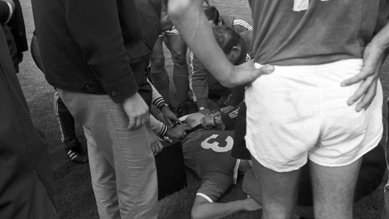 Fußball-Bundesliga, Saison 1969/1970, 4. Spieltag: Der Schalker Spieler Friedel Rausch liegt am Boden. Rausch wurde von einem Hund des Stadionsicherheitsdienstes in den Hintern gebissen.