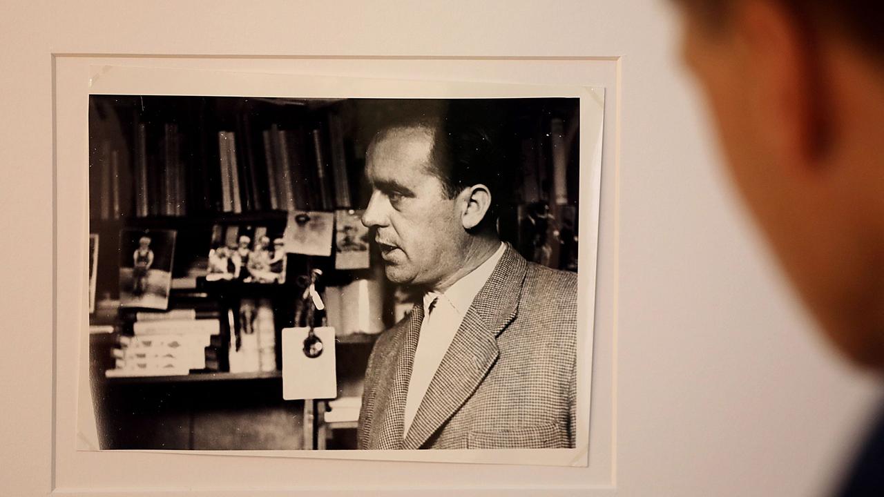 Ein Mann schaut am 29.08.2017 in Köln (Nordrhein-Westfalen) auf eine Fotografie von Heinz Held aus dem Jahr 1953, die Heinrich Böll zeigt., Sie ist in der Ausstellung  "Die humane Kamera - Heinrich Böll und die Fotografie" im Museum Ludwig zum 100. Geburtstag des Nobelpreisträgers zu sehen.