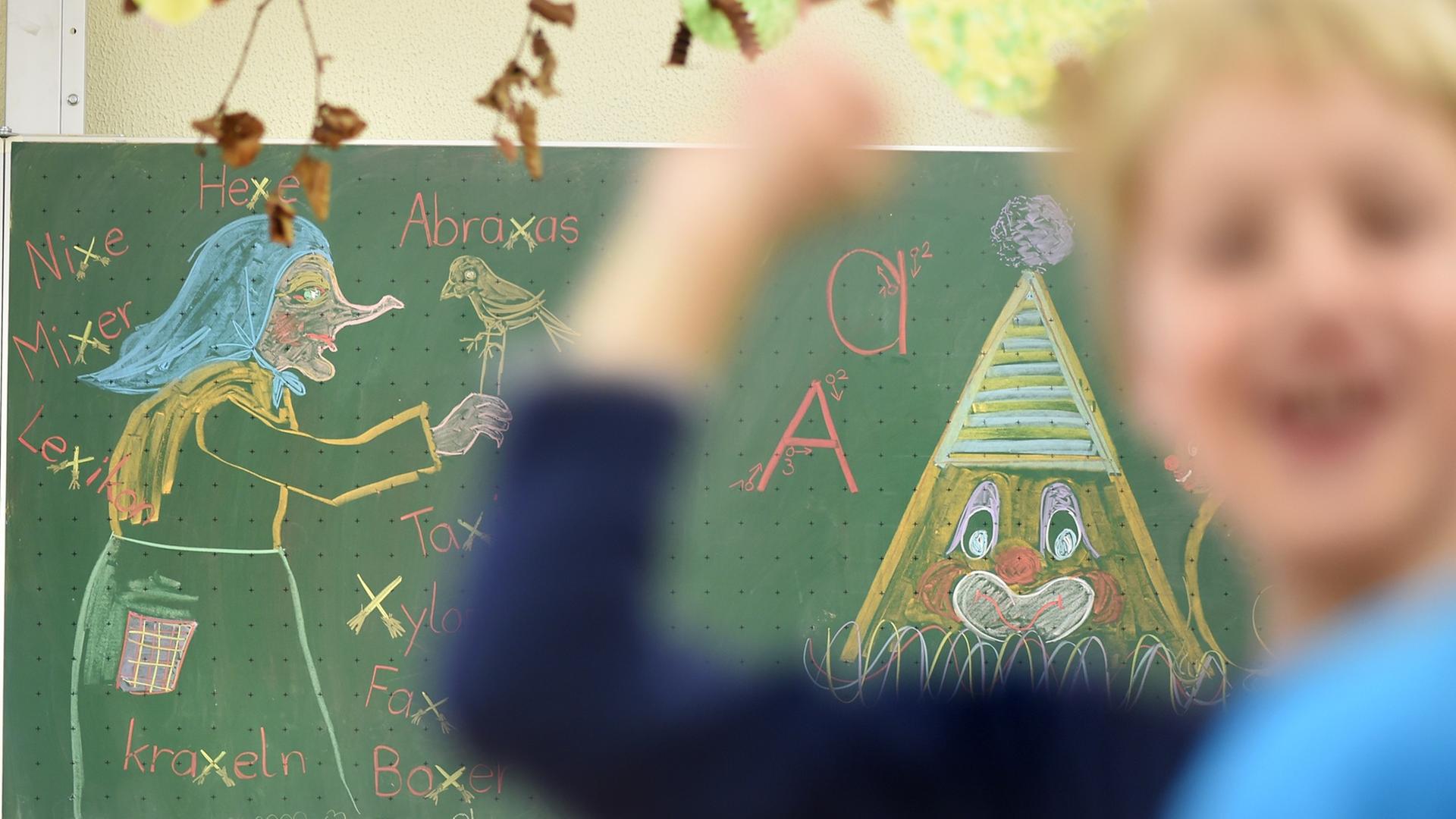 Ein Junge wirft in einem Klassenzimmer mit einem Gegenstand. Im Hintergrund ist ein Tafelbild mit einer Hexe.
