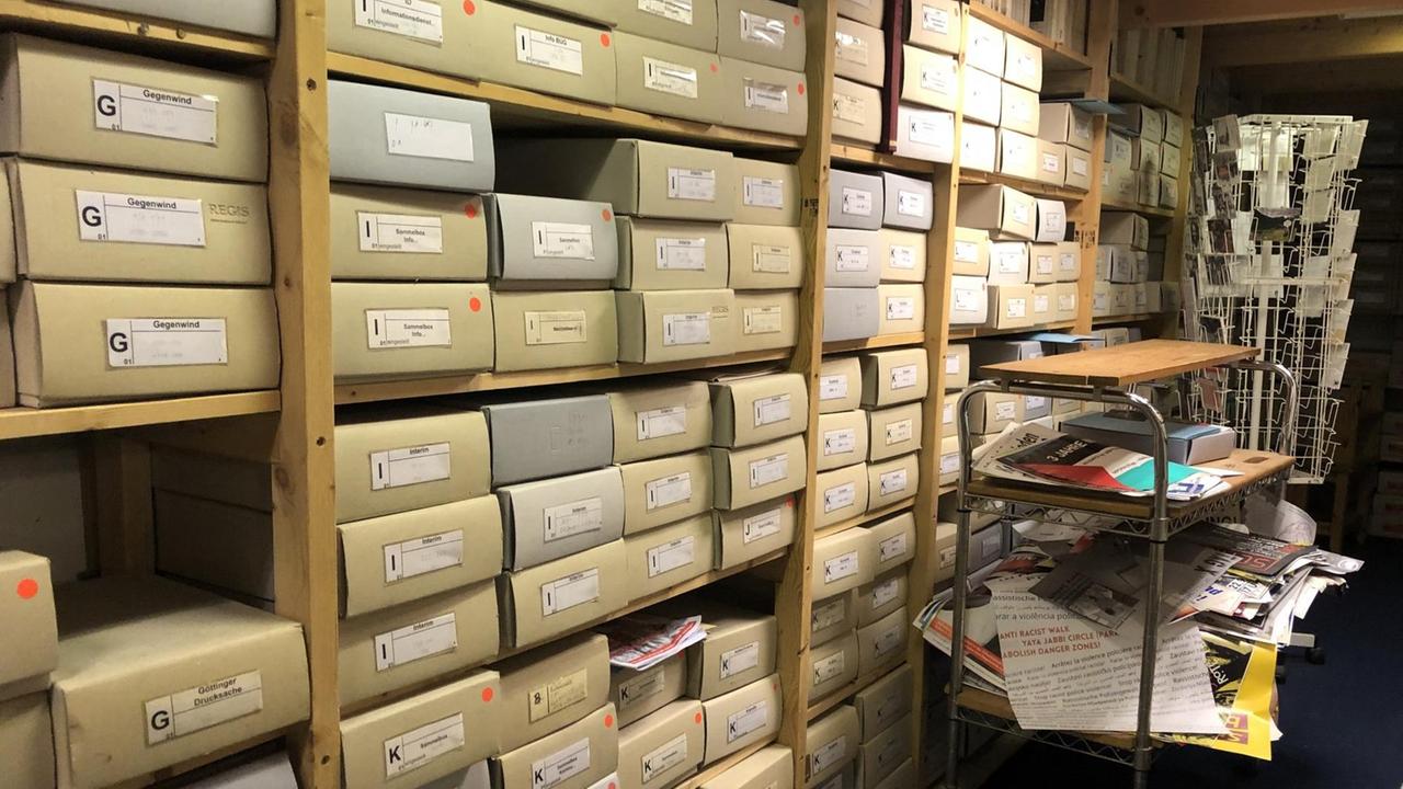 Ein langes Regal voller Pappkartons, einheitlich beschriftet, bildet das Archiv der Sozialen Bewegung.