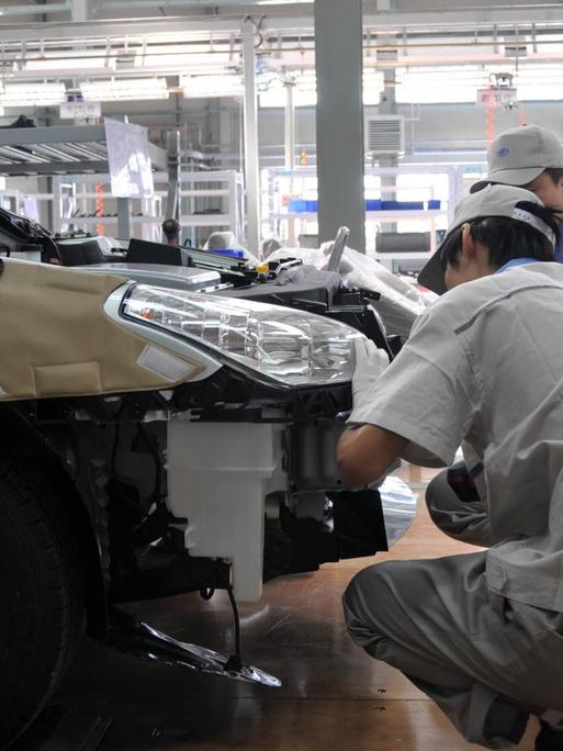 Arbeiter in einer Fertigunsstraße im VW-FAW-Werk in Changchun im Norden Chinas.