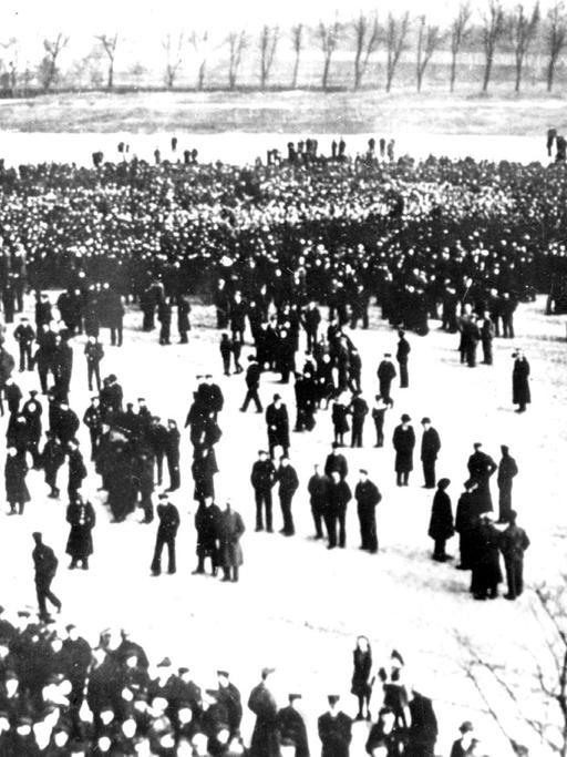 Blick auf demonstrierende Matrosen in Kiel im Oktober 1918, die den Befehl der Admiralität, trotz des Ersuchens um Friedensverhandlungen der neuen Regierung Max von Baden doch noch zu einer letzten Schlacht gegen Großbritannien auszulaufen, verweigern.