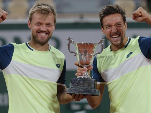 Kevin Krawietz (l) und Andreas Mies aus Deutschland feiern mit der Trophäe den Finalsieg im Doppel der French Open.