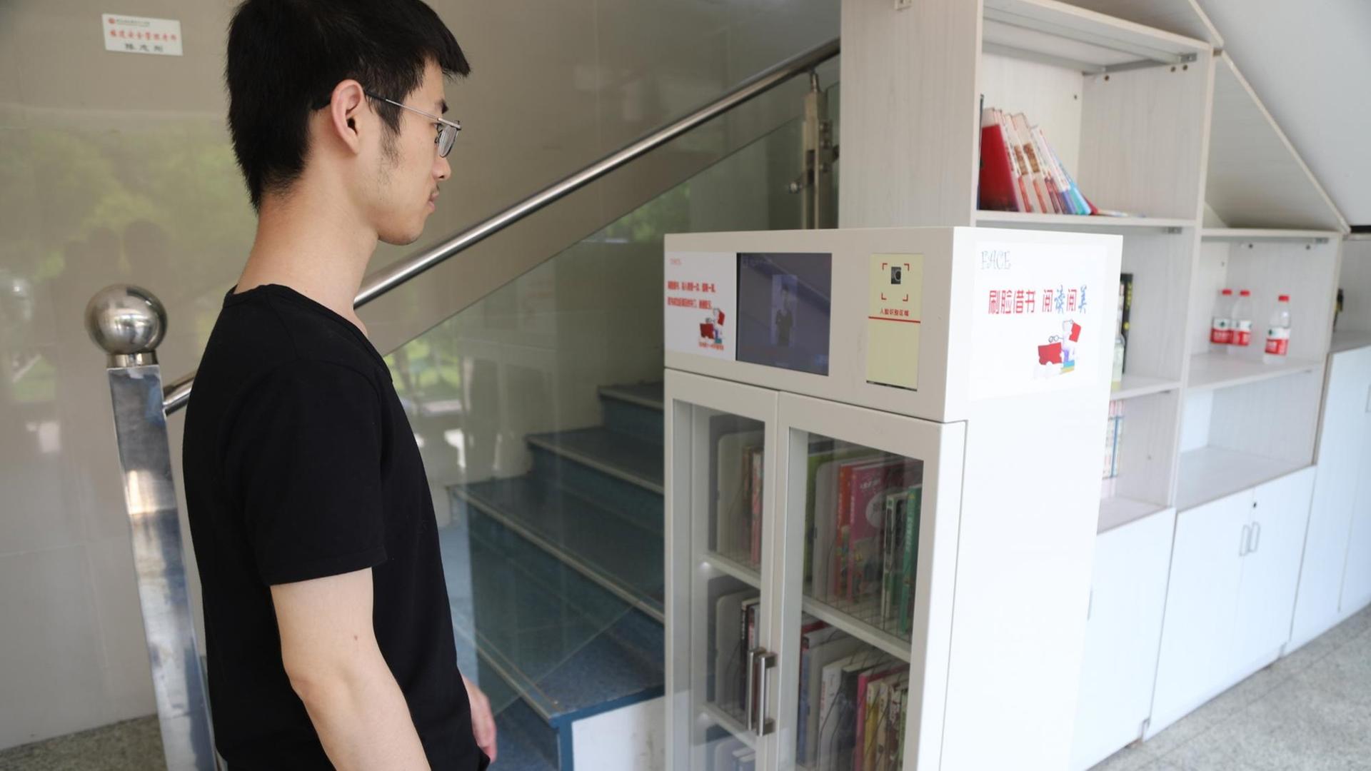 Ein Schüler leiht per Gesichtserkennung Bücher aus, in der Bibliothek der Hangzhou-Schule in China. Ein Schüler leiht per Gesichtserkennung Bücher aus, in der Bibliothek der Hangzhou-Schule in China.