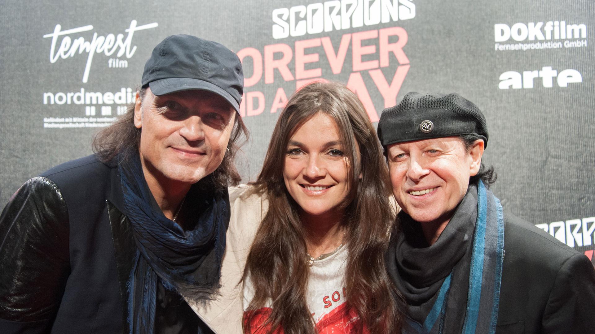 Die Scorpions-Mitglieder Matthias Jabs (l) und Klaus Meine posieren am 24.03.2015 gemeinsam mit Regisseurin Katja von Garnier bei der Premiere des Films "Scorpions - Forever and a Day" im Astor Grand Cinema in Hannover (Niedersachsen).