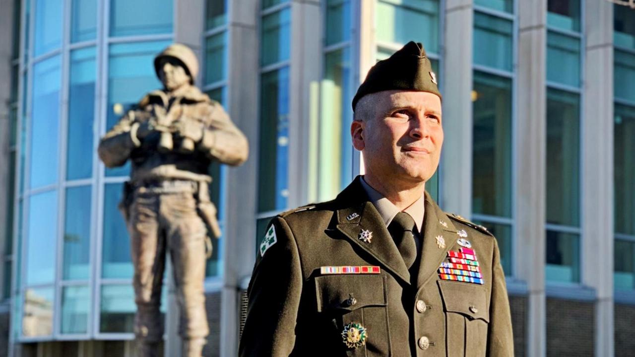 Ein Mann in US-Uniform steht vom dem Denkmal Generals George Pattons.