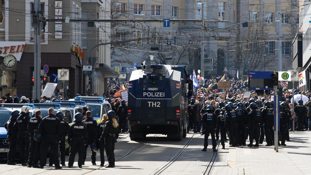 Einsatzkräfte der Polizei stehen bei einer Kundgebung unter dem Motto "Freie Bürger Kassel - Grundrechte und Demokratie" neben einem Wasserwerfer.