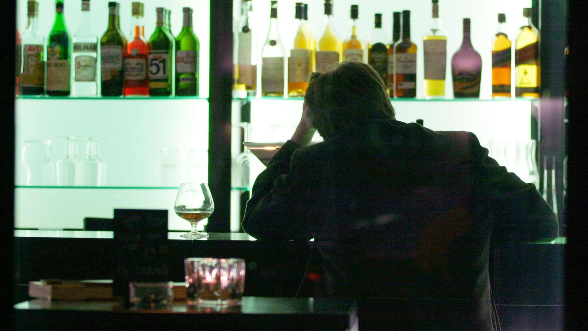 Ein Mann sitzt an einer Bar.