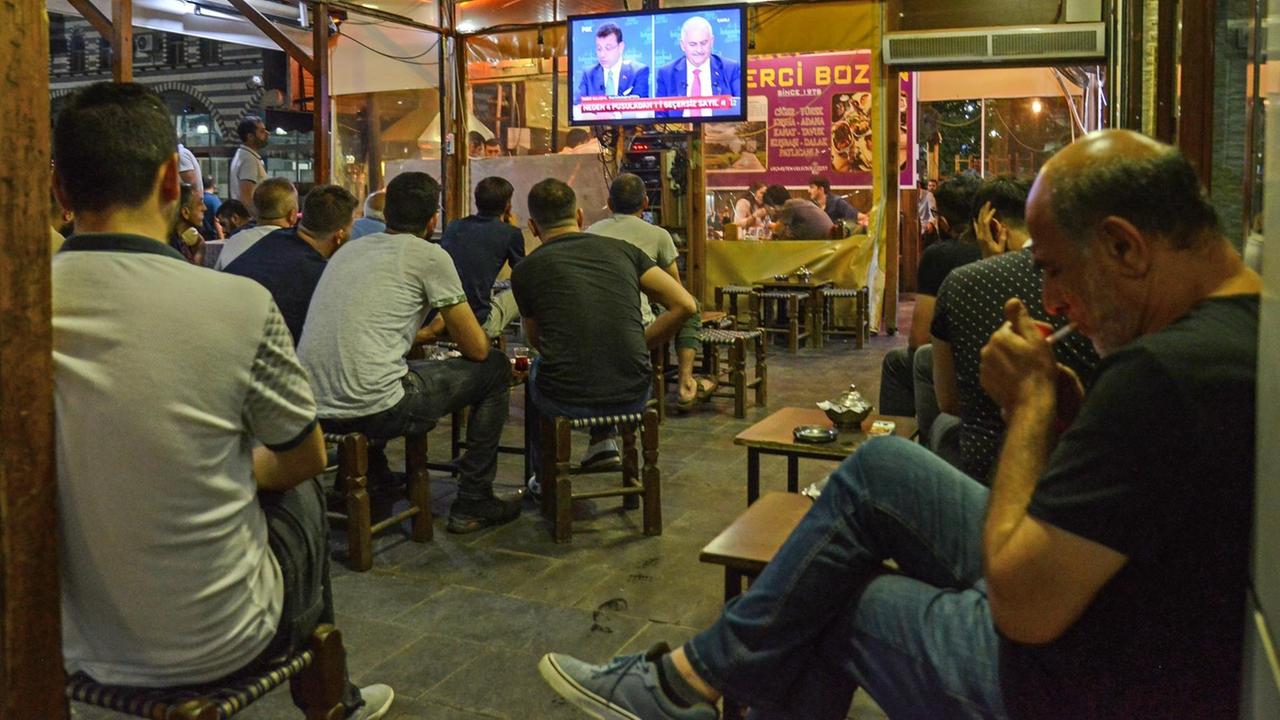 In einem Café in Diyarbakir schauen Menschen sich das TV-Duell der Istanbuler Bürgermeisterkandidaten an