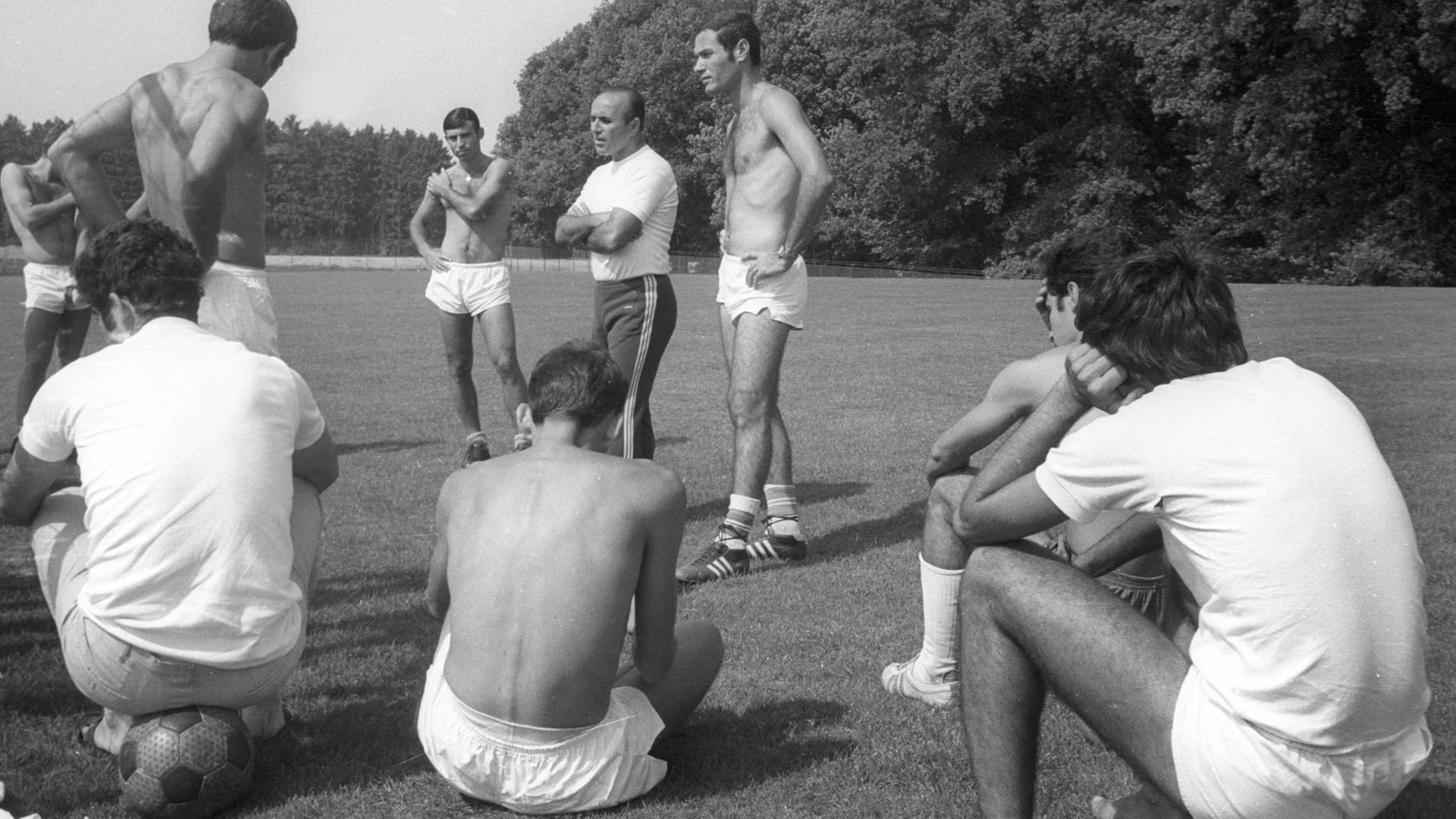 Trainer und Spieler auf einer Wiese