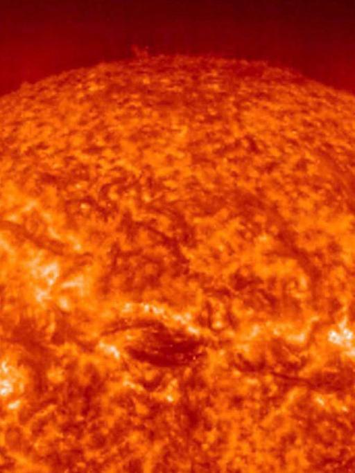 Als glutroter, lebensfeindlicher Feuerball präsentiert sich die 149,6 Millionen Kilometer von der Erde entfernte Sonne aus der Nähe: Das UV-Foto wurde vom EIT-Teleskop an Bord der Sonnen- und Heliosphären-Observationsraumsonde SOHO der NASA am 20.12.2000 aufgenommen. Die Fleckenstruktur ergibt sich durch die unterschiedlichen Temperaturen (zwischen 60000 und 80000 Grad) auf der Sonnenoberfläche. In der Korona, dem leuchtenden, äußersten Kranz um die Sonne, werden Temperaturen bis 1,5 Millionen Grad Celsius erreicht.