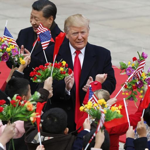 Donald Trump (r.) und Xi Jinping werden von Blumen und Flaggen schwenkenden Kindern begrüßt.
