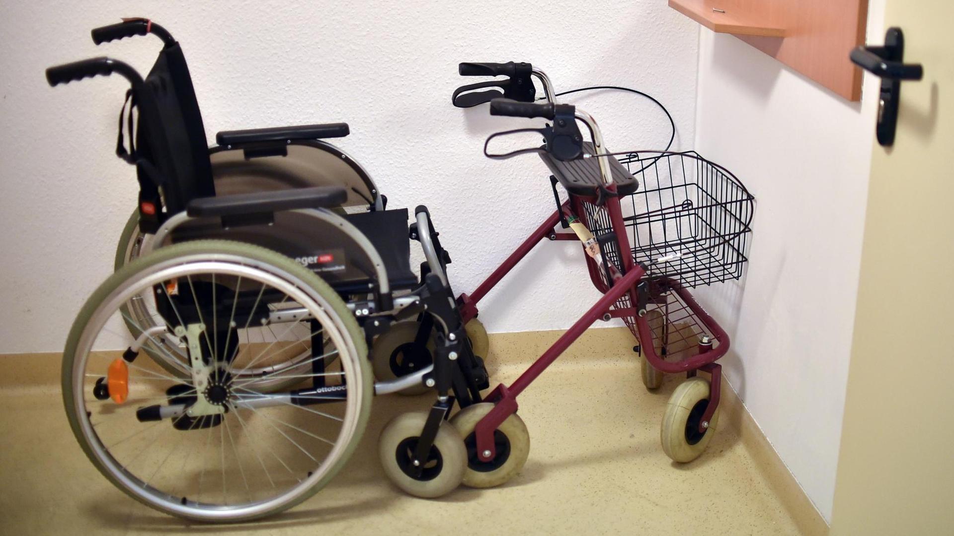 Ein Rollator und ein Rollstuhl stehen in einer Ecke.