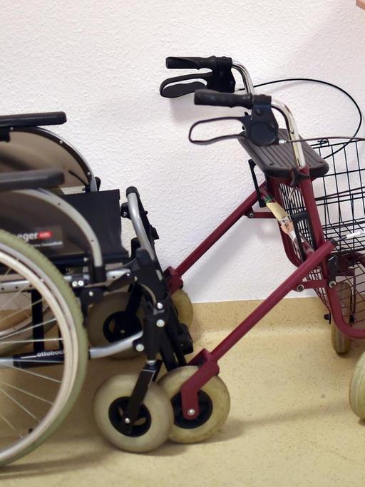Ein Rollator und ein Rollstuhl stehen in einer Pflegeeinrichtung in einer Ecke.
