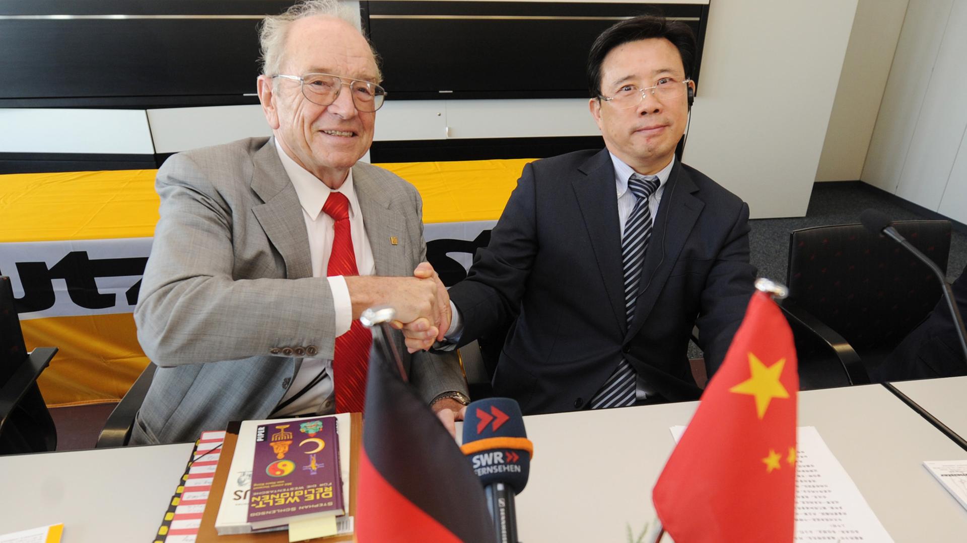 Der Gründer der Betonpumpen-Firma Putzmeister, Karl Schlecht, und der Chairman der SANY Group, Wengen Liang – April 2012 in Aichtal.
