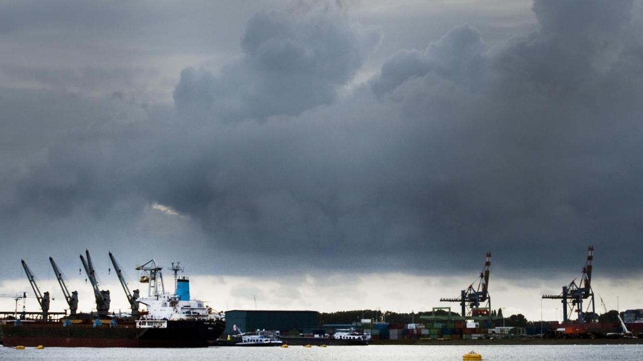 Rotterdamer Hafen mit Wolken am Horizont.