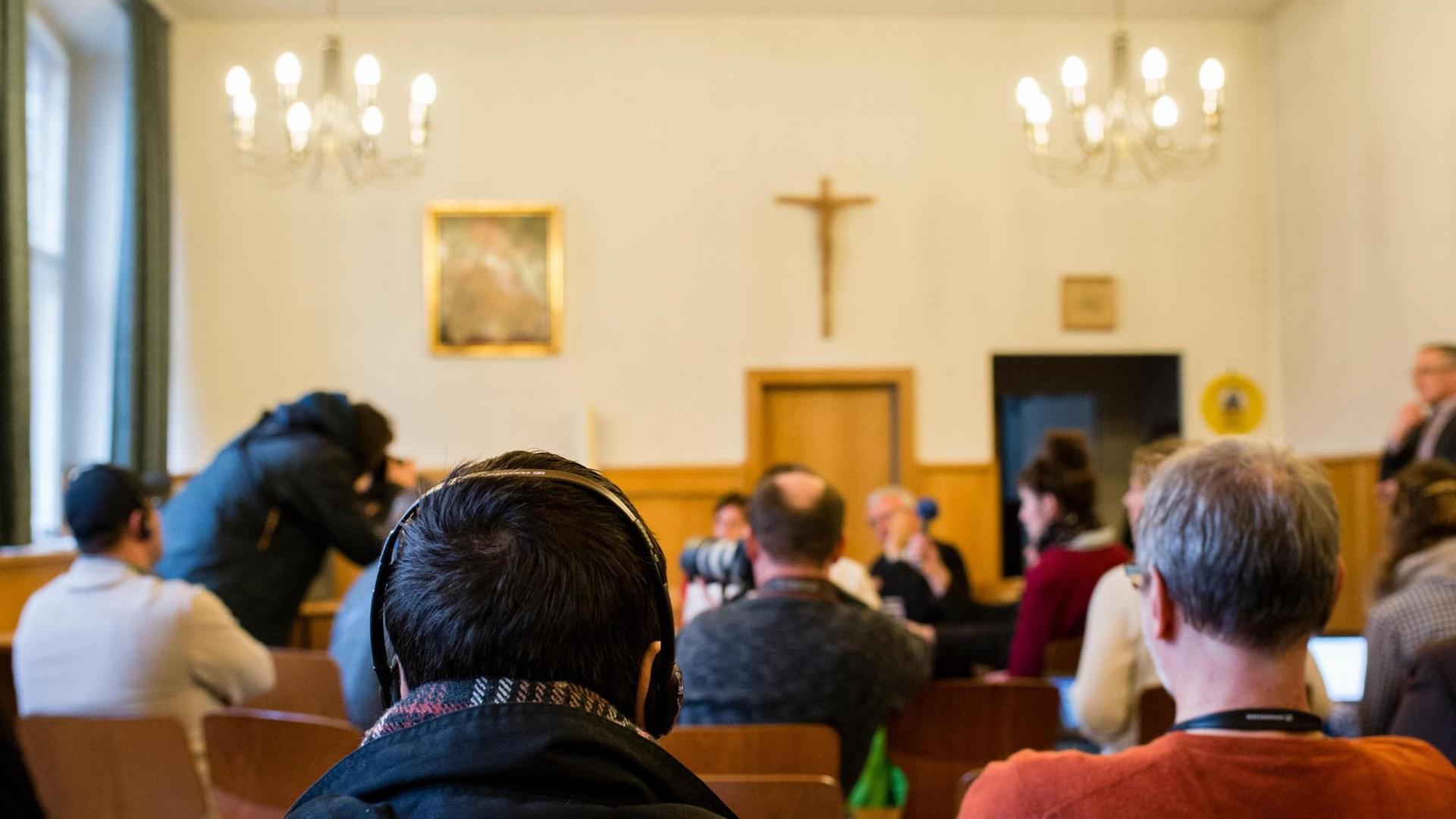 Ein Flüchtling hört sich am 21.03.2016 die Übersetzung eines Pressegespräches zu christlichen Flüchtlingen und ihrer Unterbringung in der katholischen Kirche St. Elisabeth in Berlin, in Arabisch über Kopfhörer an.