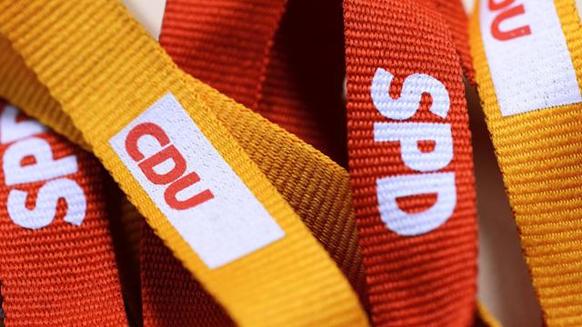 Logos von CDU und SPD auf Schlüsselbändern.