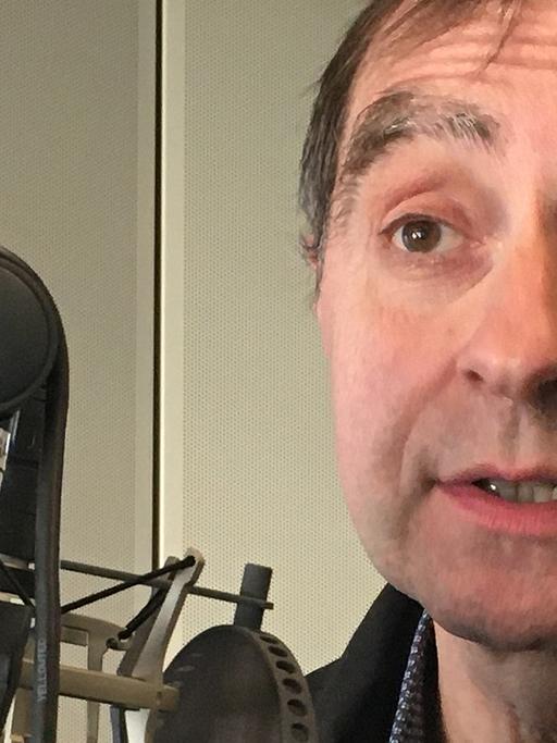 Der Galerist Rupert Pfab am Mikrofon in einem Studio von Deutschlandfunk Kultur.