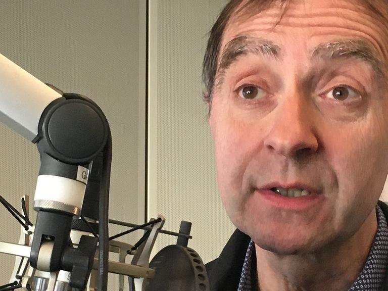 Der Galerist Rupert Pfab am Mikrofon in einem Studio von Deutschlandfunk Kultur.