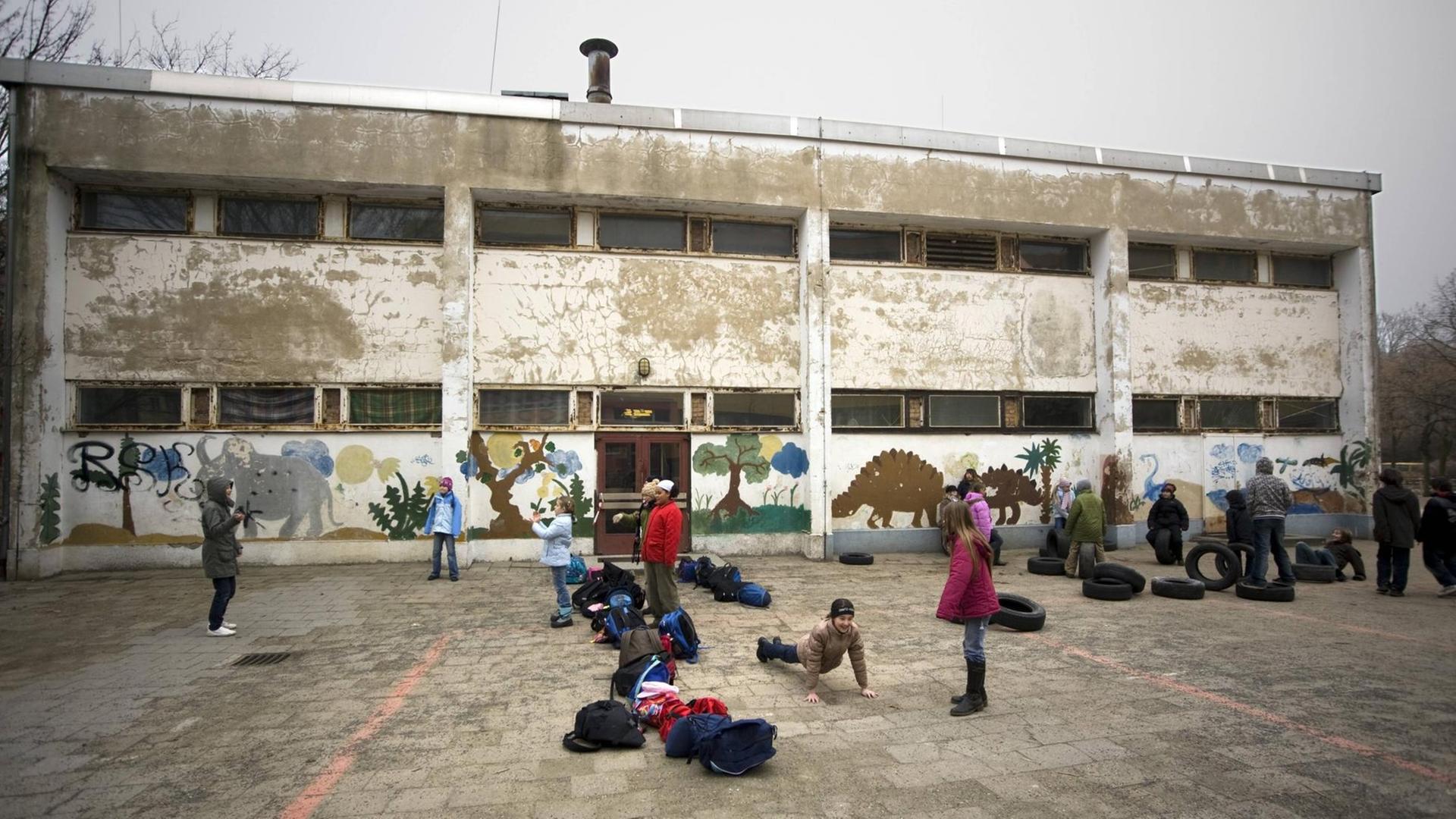 Grundschüler in Berlin vor einer maroden Turnhalle.
