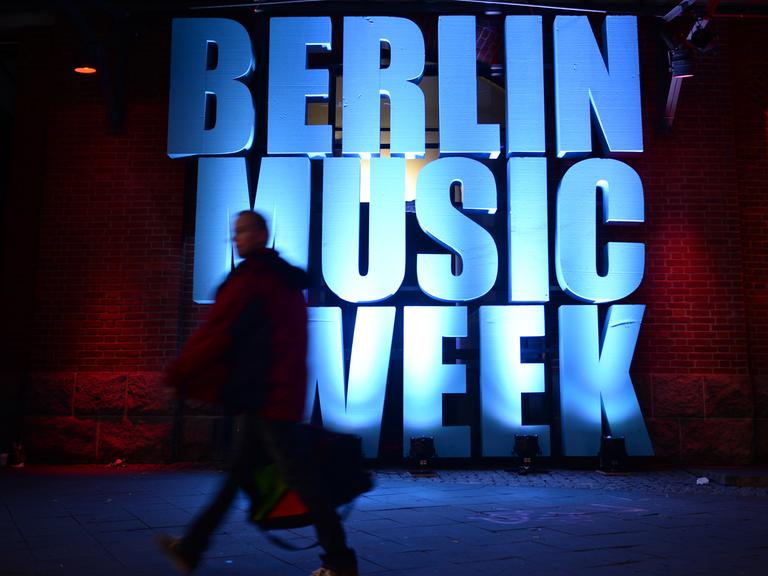Ein Besucher geht an einem beleuchteten Schriftzug "Berlin Music Week" vorbei.