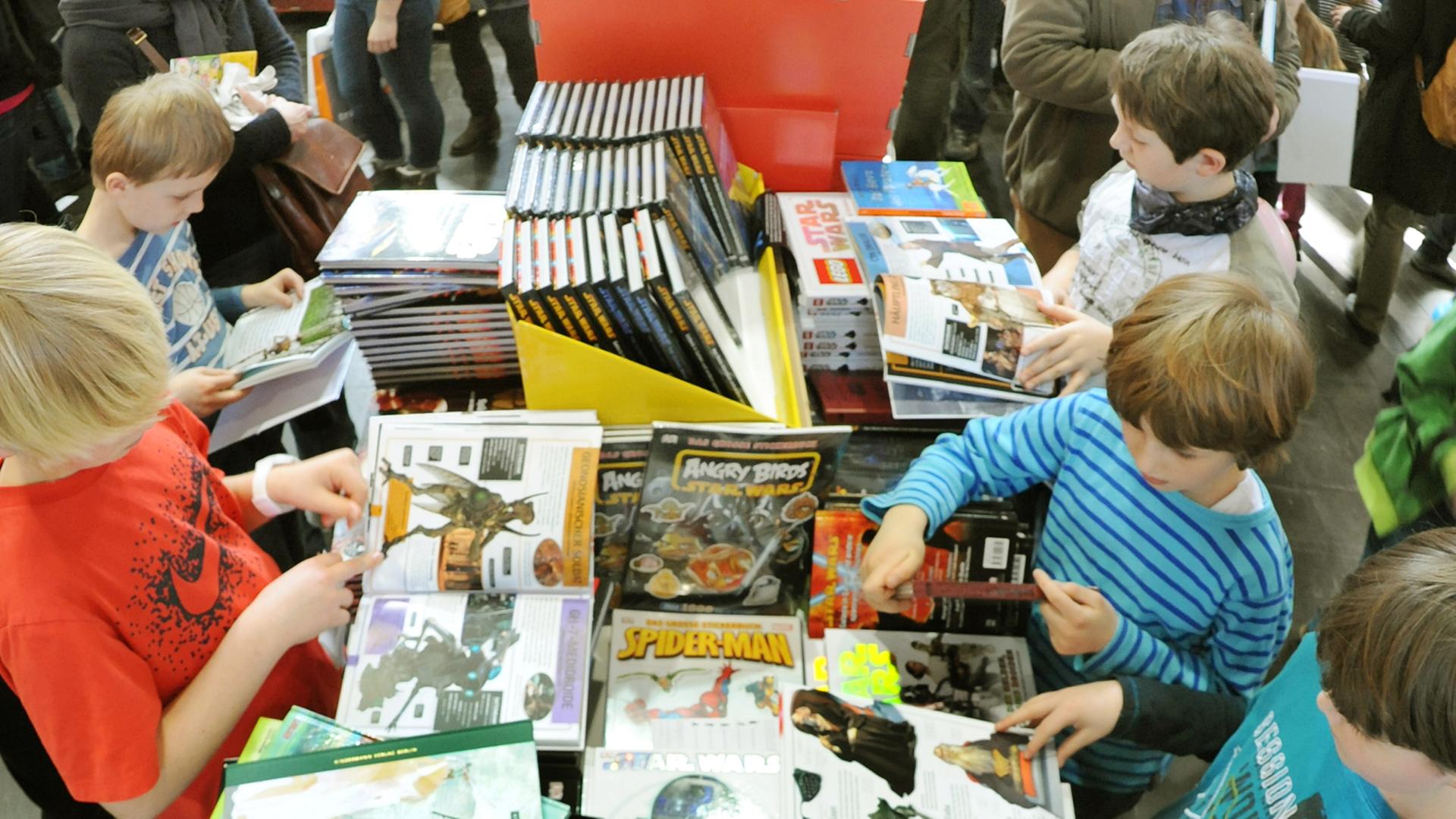 Auf der Buchmesse in Leipzig schauen sich Besucher in der Kinderbuchhandlung Bücher an, aufgenommen am 17.03.2013. Foto: Waltraud Grubitzsch