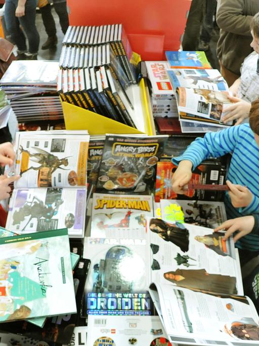 Auf der Buchmesse in Leipzig schauen sich Besucher in der Kinderbuchhandlung Bücher an, aufgenommen am 17.03.2013. Foto: Waltraud Grubitzsch