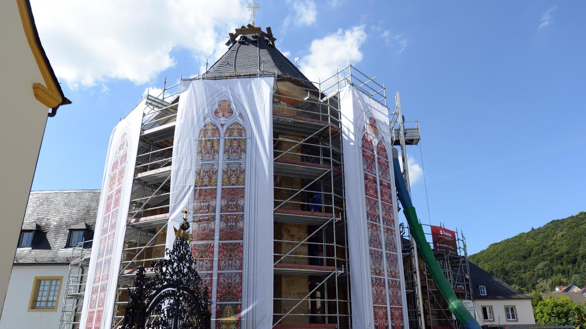 Das Foto zeigt die Kirche von Tholey. Als Fahne hängen die Fenster von Gerhard Richter von dem Gebäude herunter.