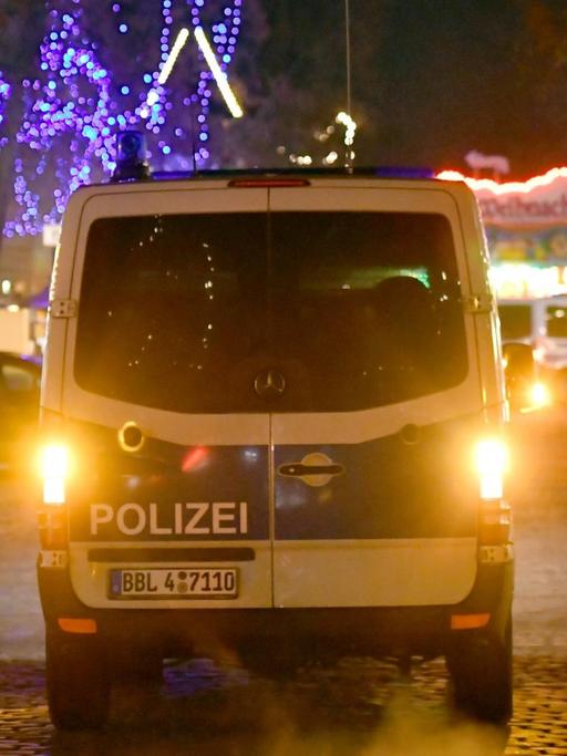 Ein Polizeifahrzeug fährt am 01.12.2017 auf einer Straße an einen Weihnachtsmarkt in der Innenstadt von Potsdam (Brandenburg). An dem Markt haben Bombenentschärfer am Freitag ein verdächtiges Paket unschädlich gemacht.