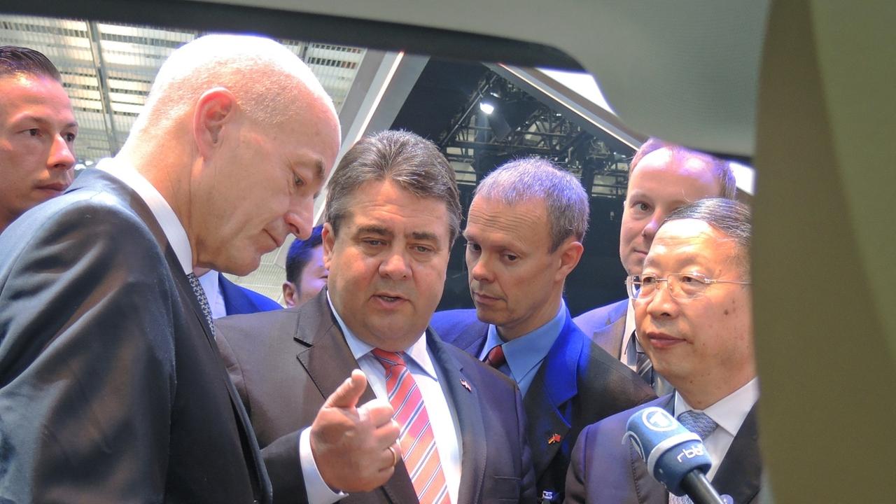 Der China-Chef von BMW, Karsten Engel (l), zeigt Bundeswirtschaftsminister Sigmar Gabriel (SPD, M) und dem chinesischen Vize-Industrieminister Su Bo (r) am 23.04.2014 auf der Automesse in Peking das Elektroauto i3 des bayerischen Autobauers. Foto: Tim Bra Der China-Chef von BMW, Karsten Engel (l), zeigt Bundeswirtschaftsminister Sigmar Gabriel (SPD, M) und dem chinesischen Vize-Industrieminister Su Bo (r) am 23.04.2014 auf der Automesse in Peking das Elektroauto i3 des bayerischen Autobauers. Foto: Tim Bra