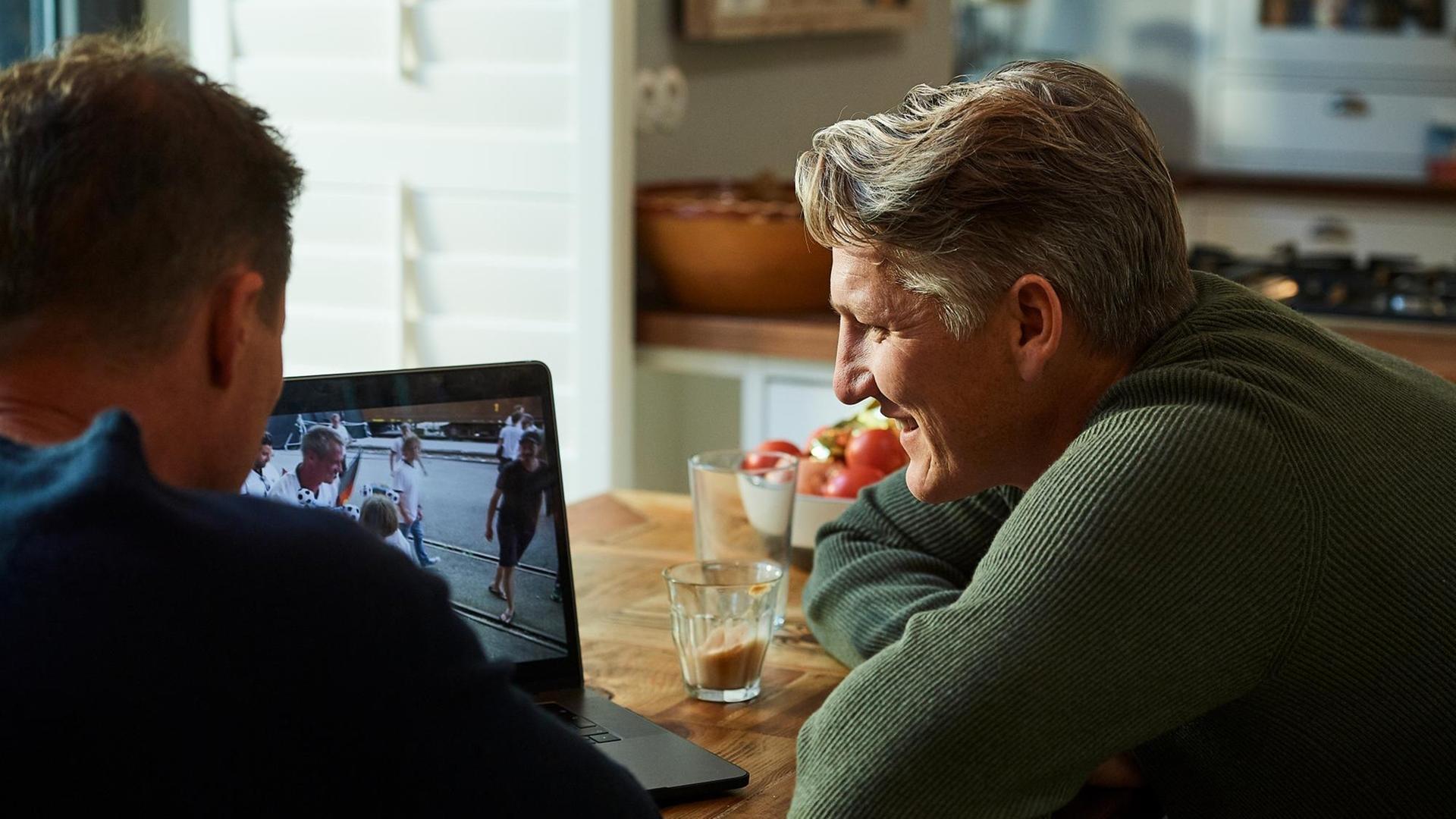 Sebastain Schweinsteiger und Til Schweiger schauen gemeinsam auf einen Laptop