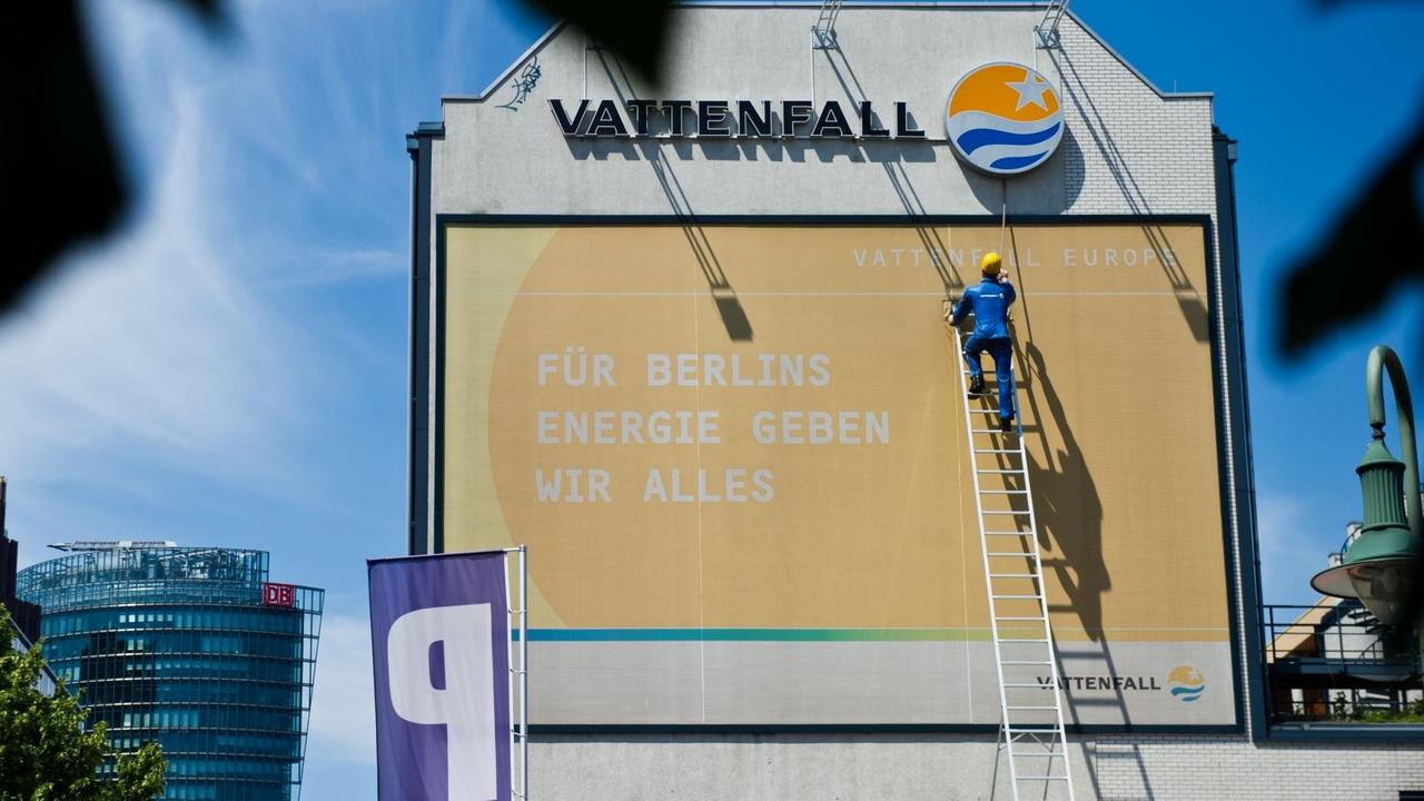 Eine Figur in Form eines Technikers scheint in Berlin über eine überdimensionale Leiter die Kältezentrale der Vattenfall Europe Wärme AG im Vordergrund der Hochhäuser des Potsdamer Platzes zu erklimmen.