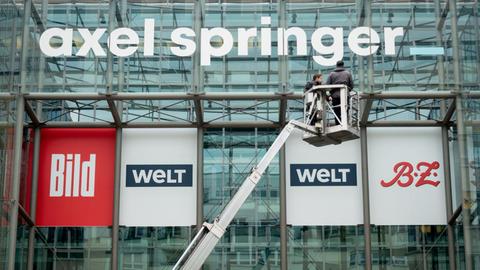Das neu gestaltete Logo des Medienkonzerns Axel Springer wird an der Fassade der Unternehmenszentrale in Berlin befestigt.