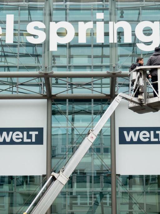 Das neu gestaltete Logo des Medienkonzerns Axel Springer wird an der Fassade der Unternehmenszentrale in Berlin befestigt.