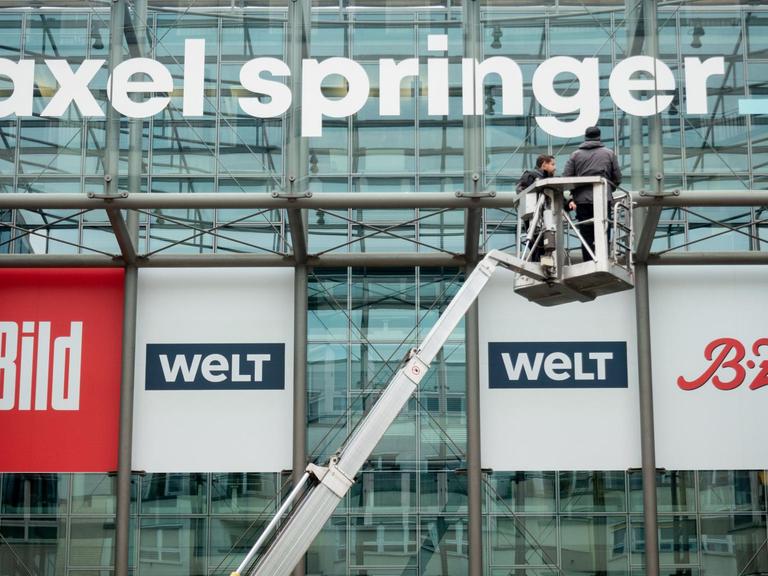 Das neu gestaltete Logo des Medienkonzerns Axel Springer wird an der Fassade der Unternehmenszentrale in Berlin befestigt.