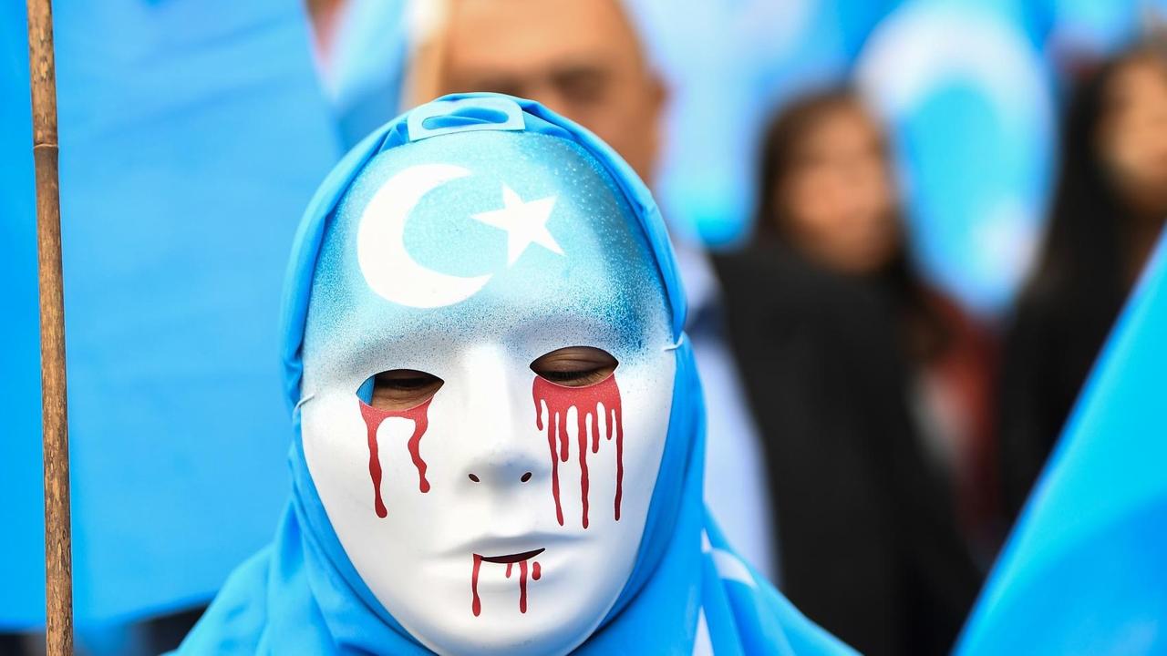 27. April 2018 in Brüssel: Maskierte Person auf einem Protestmarsch für die Schließung der chinesischen Umerziehungslager, in denen Uiguren aus der Autonomen Region Xinjiang festgehalten werden