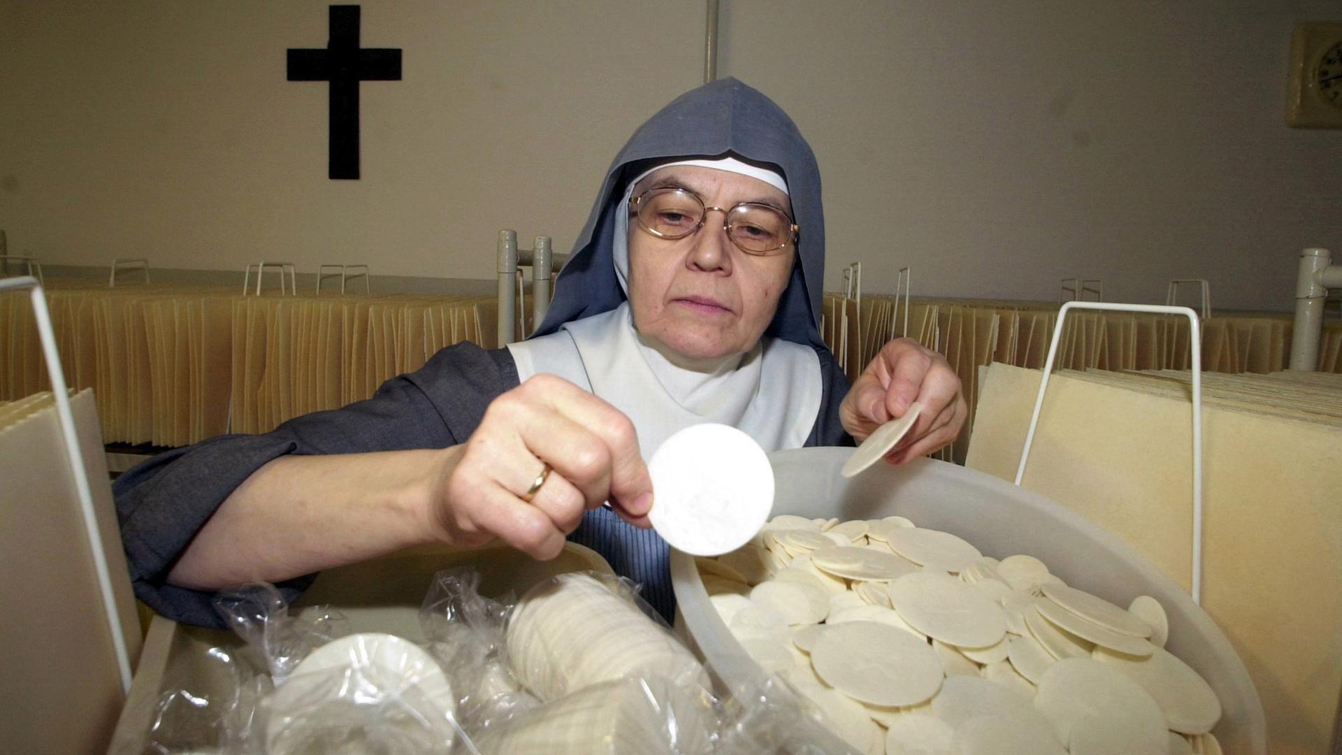 Die Qualität der frisch gebackenen Hostien prüft Schwester Diethild in der Hostienbäckerei der Benediktinerinnenabtei Varensell in Rietberger.