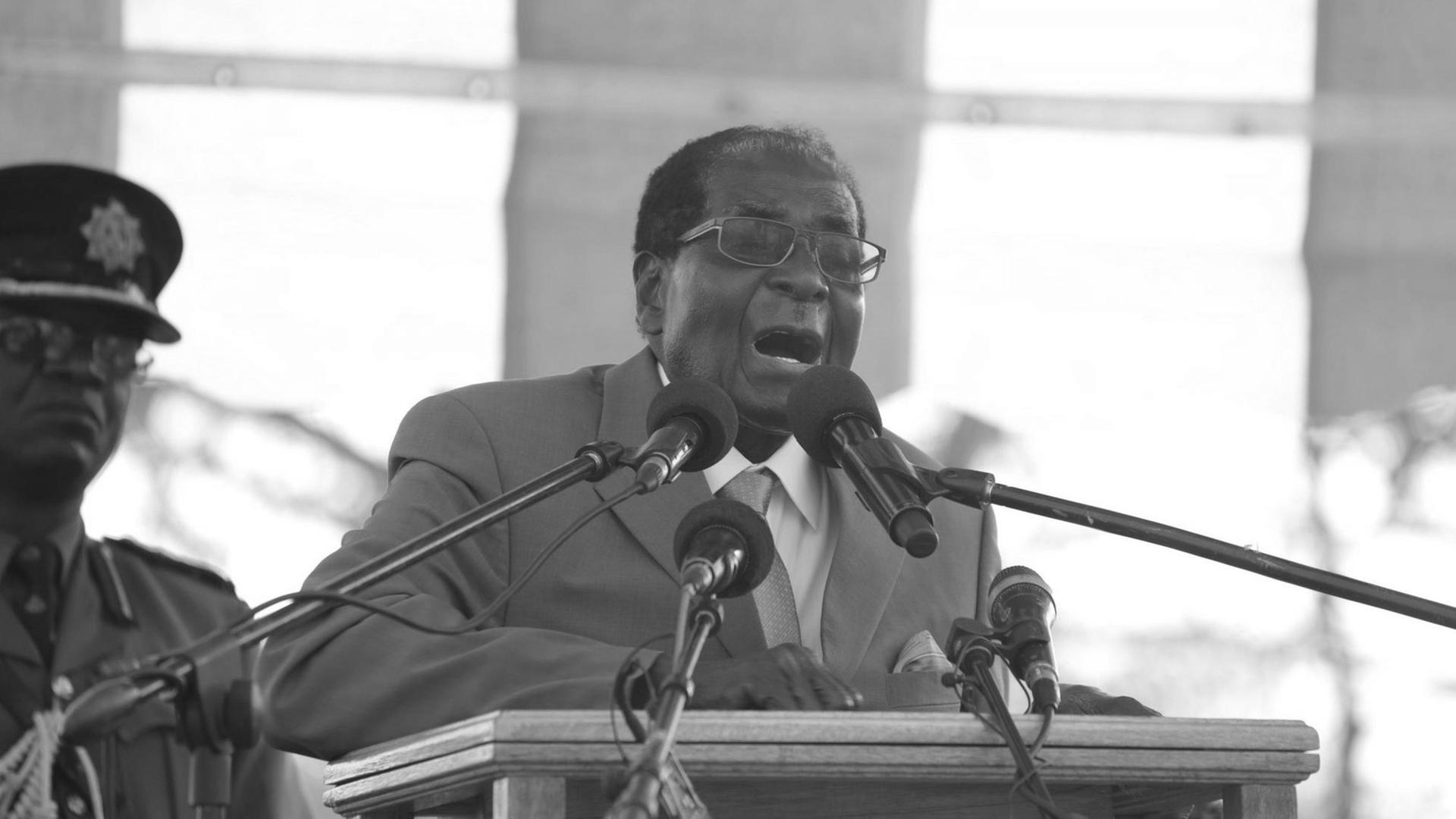 Robert Mugabe steht vor Mikrofonen.