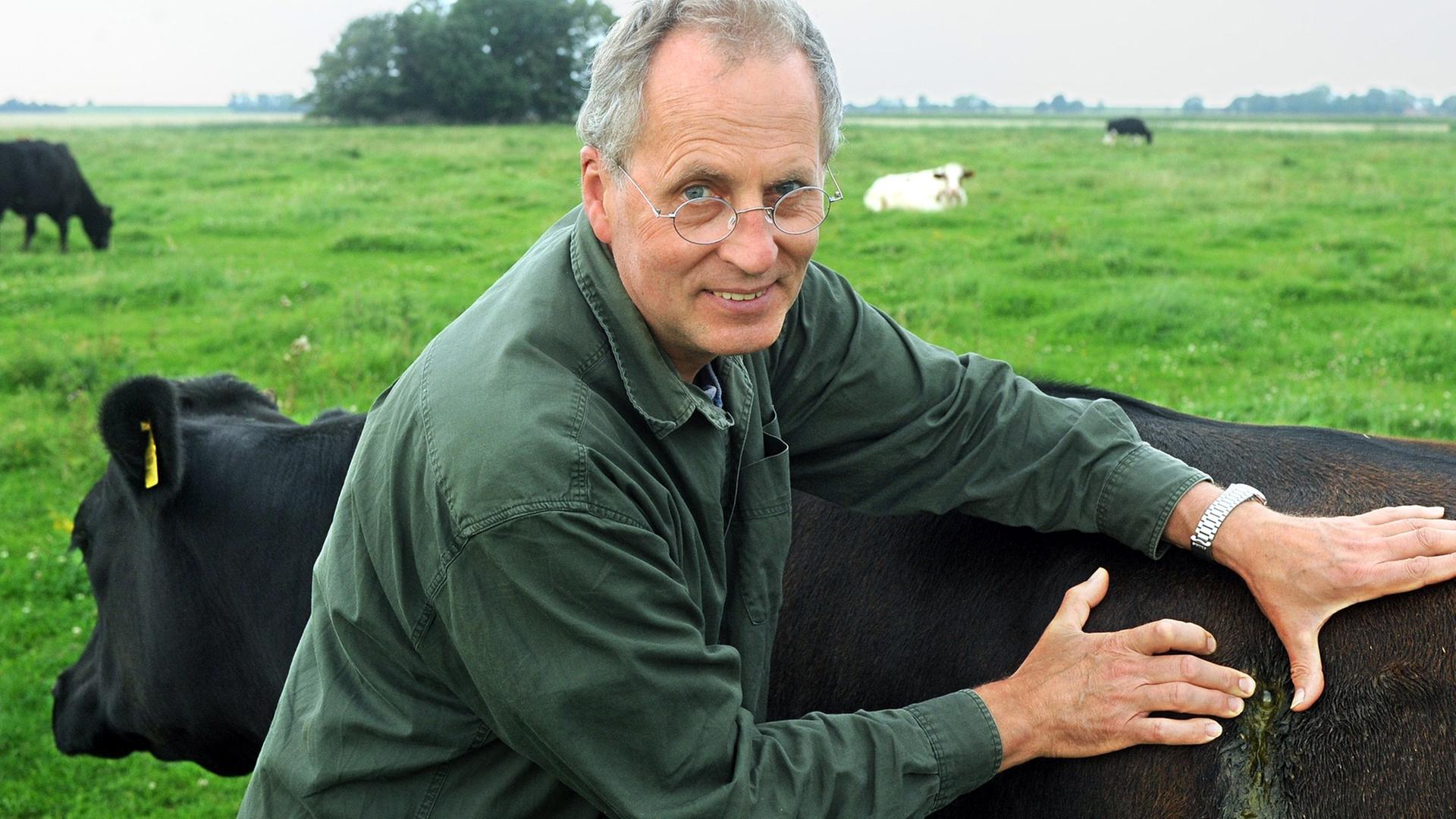 Der Landwirt und Tierschützer Jan Gerdes auf der Weide mit Kuh Manuela.
