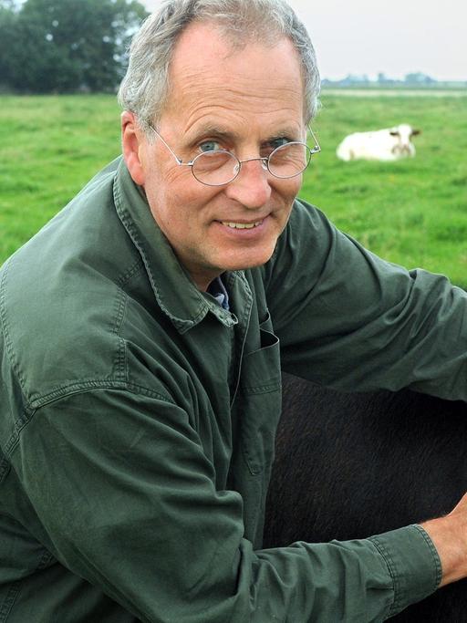 Der Landwirt und Tierschützer Jan Gerdes auf der Weide mit Kuh Manuela.