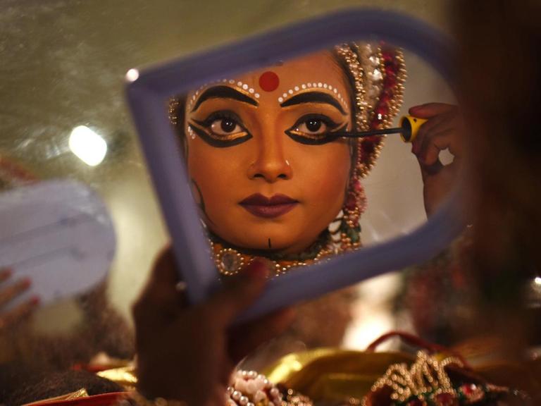 Eine Künstlerin, die Sita spielt, schminkt sich und bereitet sich auf eine Aufführung in Deu Delhi vor.