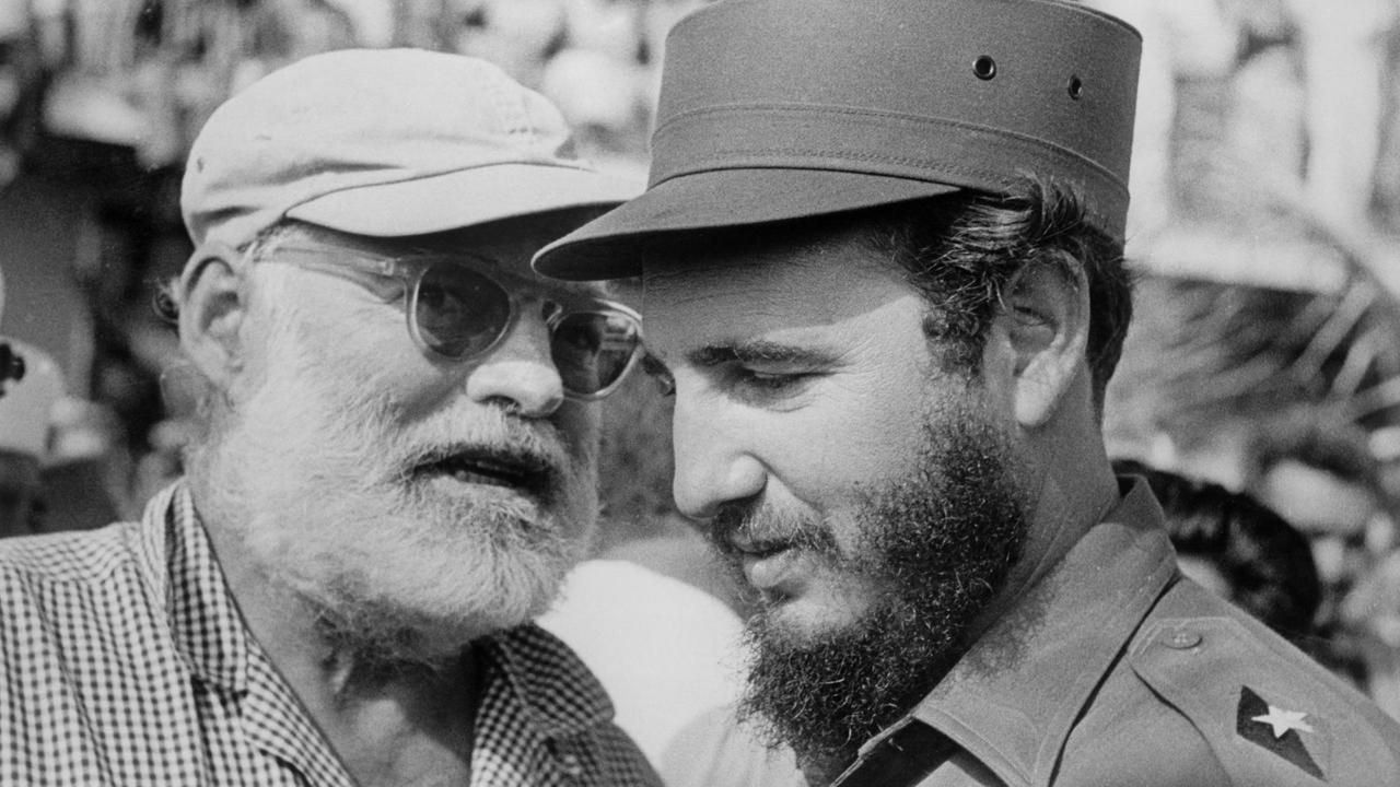 Hemingway, mit weißer Cappy und Sonnebrille, redet mit Castro.