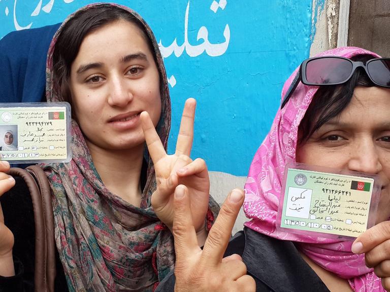 Frauen, die 2014 bei der Präsidentschaftswahl in Afghanistan ihre Stimme abgeben. Unter Taliban-Herrschaft undenkbar. Sie zeigen das Victory-Zeichen.