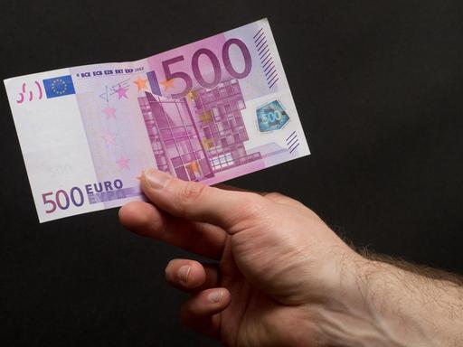 Ein 500-Euro-Schein in der Hand eines Mannes.