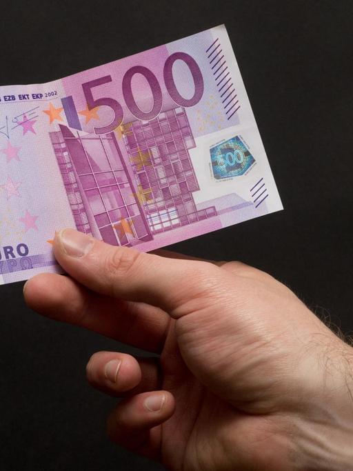 Ein 500-Euro-Schein in der Hand eines Mannes.