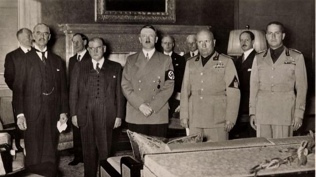 Historische Aufnahme von 1938: Die Politiker Chamberlain, Daladier, Hitler, Mussolini und Galeazzo Ciano stehen in einer Reihe nebeneinander.